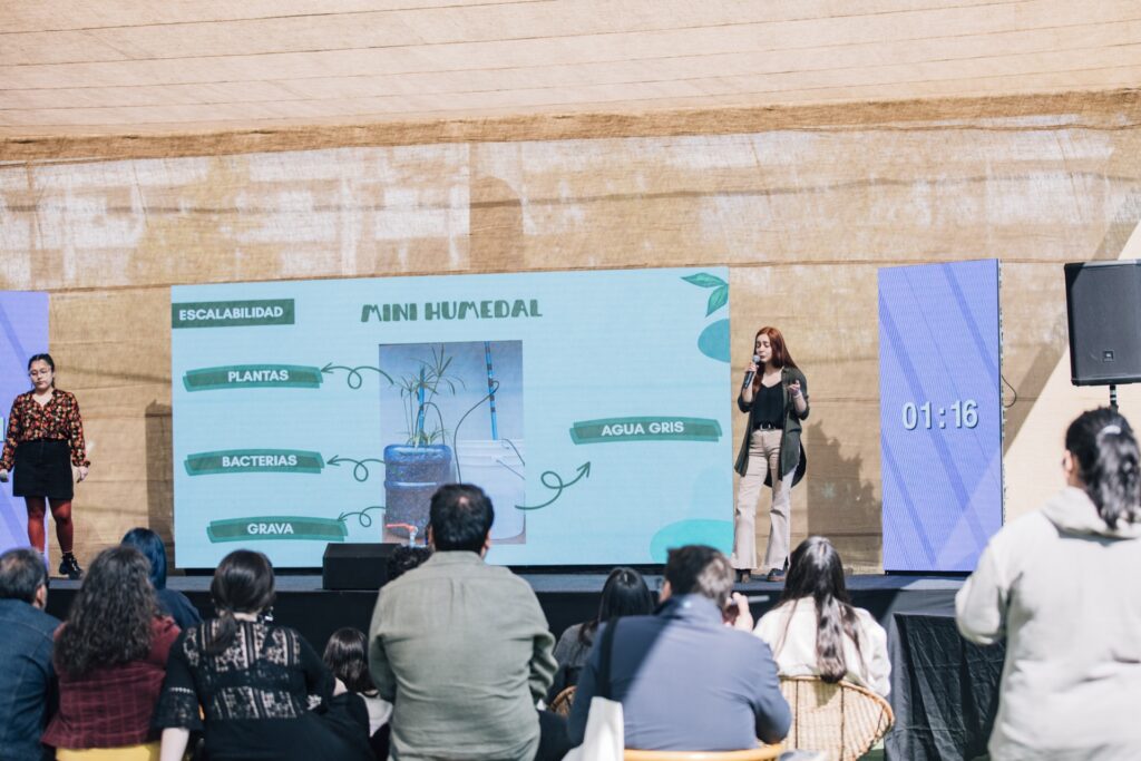 Equipo presentando el proyecto Mini Humedal en escenario del evento Sinapsis USACH